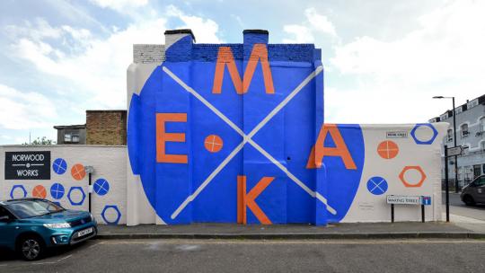Street view of workspace in West Norwood showing big red letters M A K E on a blue dot on the side of a building