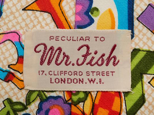 Close up of the inside of a colourful, Seventies style shirt with the label reading ‘ Perculiar to Mr Fish 17, Clifford Street, London, W.1’